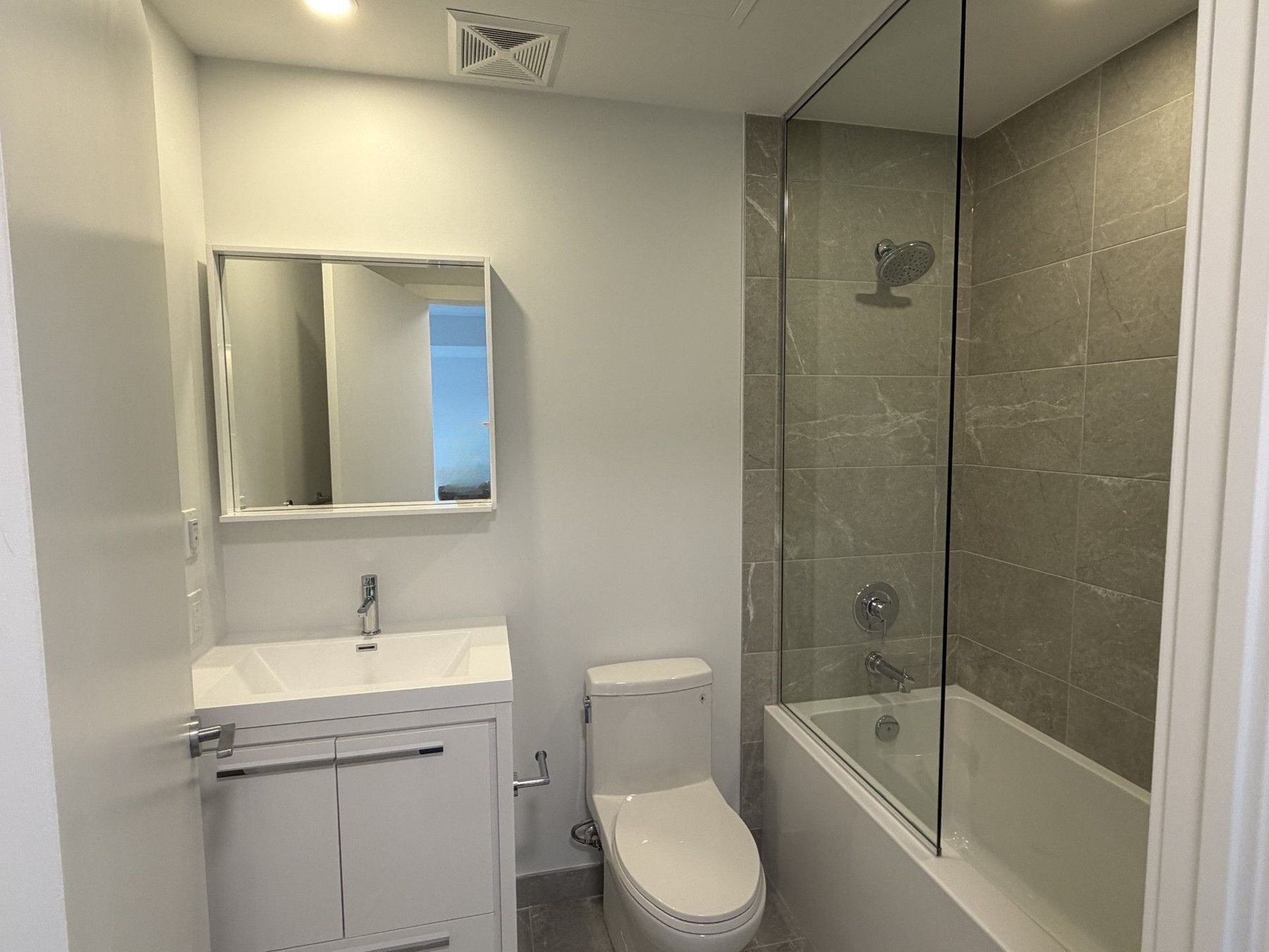 Bathroom vanity and glass tub shower